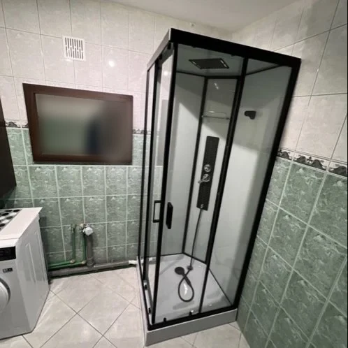 Łazienka z czarną kabiną prysznicową i pralką — DobryHydraulik Wrocław