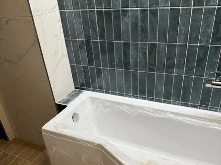 Nowa wanna przy granatowych płytkach — DobryHydraulik Wrocław